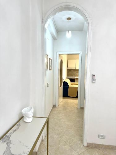 a hallway with a table and a room with a bed at Maison 94 in Scilla