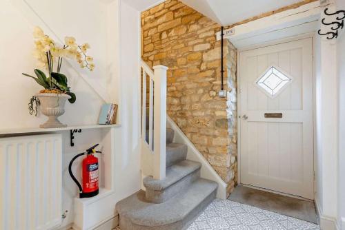 a staircase in a house with a fire extinguisher at Badgers Den in Blockley
