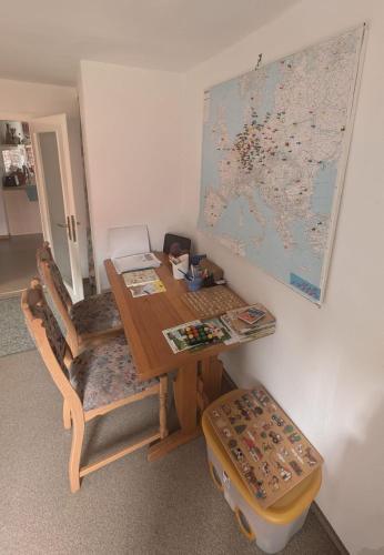 a wooden table with chairs and a map on a wall at Ferienwohnung Janke in Nossen