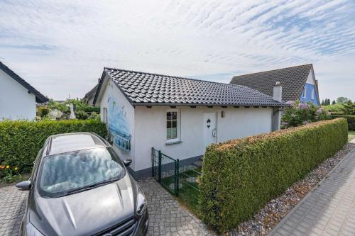 a car parked in front of a white house at FH Mimi in Ostseebad Karlshagen