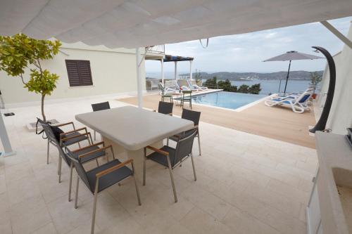 オラサックにあるVilla Judita Dubrovnikのダイニングルーム(テーブル、椅子付)、プール