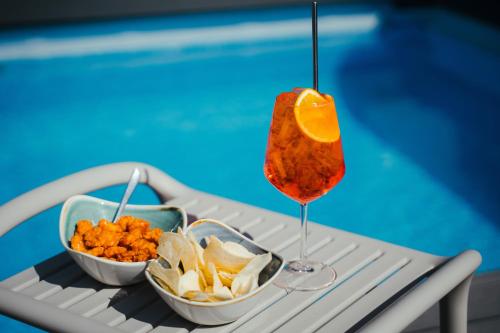 a drink and snacks on a tray next to a pool at Ollen apartments in Catania