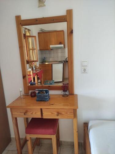 a wooden desk with a mirror and a red chair at Katerina studios D Lentas in Léntas