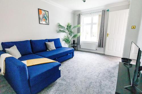 a blue couch in a living room with a window at 2Bed Garden & Private Parking Near A19 - Perfect for Contractors in Pallion
