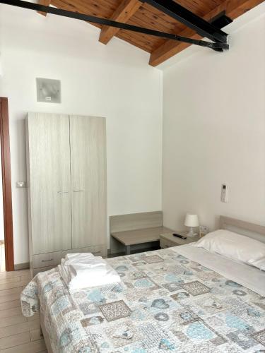a white bedroom with a bed and a wooden ceiling at Il Veliero in Marzamemi