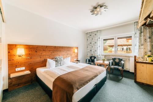 a hotel room with a large bed and a window at Hotel Alpensonne in Bad Wiessee