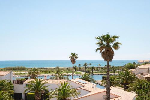 a view of a resort with a pool and palm trees at Relais et Châteaux Thalasso & Spa Ile de la Lagune in Saint-Cyprien