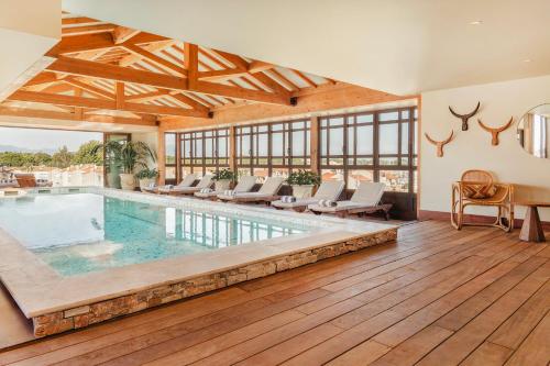 an indoor pool with chairs and a table in a house at Relais et Châteaux Thalasso & Spa Ile de la Lagune in Saint-Cyprien