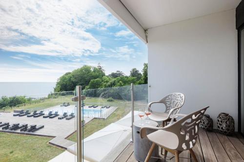 a room with a balcony with a view of the ocean at Fredensborg Badehotel in Rønne