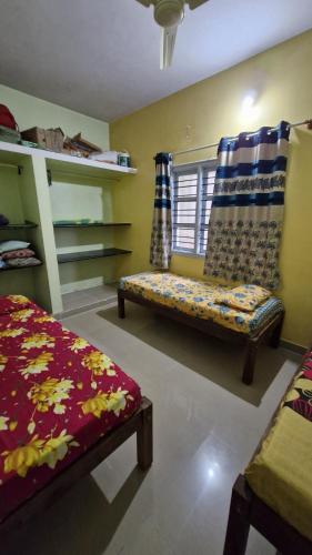 a living room with a bench and a window at Malgudi Mane Homestay in Chikmagalūr