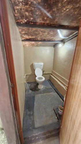 a small bathroom with a toilet in a room at Malgudi Mane Homestay in Chikmagalūr