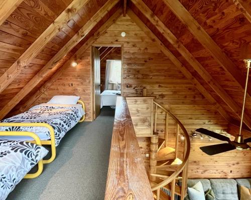 a attic bedroom with two beds and a staircase at Snow Chalet - Ohakune Chalet in Ohakune