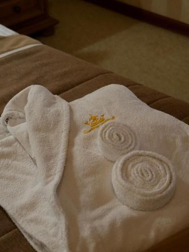 a towel on a bed with two towels at Курортний Готель Золота Корона in Truskavets