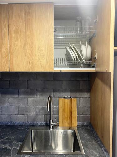 a kitchen with a sink and a shelf with utensils at Komrat Apartments in Almaty