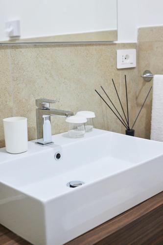 a white sink with a faucet in a bathroom at Napodano Apartments - Napoli Salerno in Sant'Egidio del Monte Albino