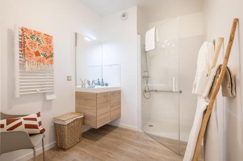 a white bathroom with a sink and a shower at Oh Activ Cergy in Cergy