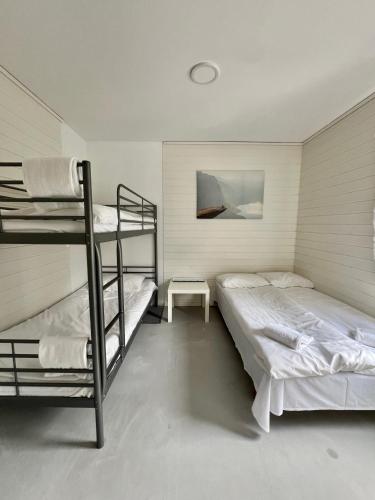 a bedroom with two bunk beds and a table at Trolltunga Studios in Odda