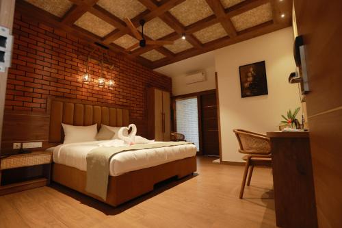 a bedroom with a bed and a brick wall at CMK HABITAT CENTRE in Ernakulam