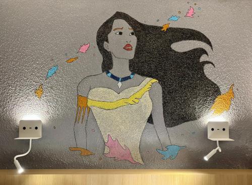 a painting of a woman on a wall at initial by balladins Tours Sud in Chambray-lès-Tours