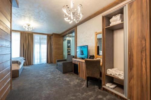 a hotel room with a bed and a television at V Chalet Residence in Velingrad