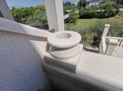 a toilet sitting on the side of a balcony at Apartments White House in Supetar