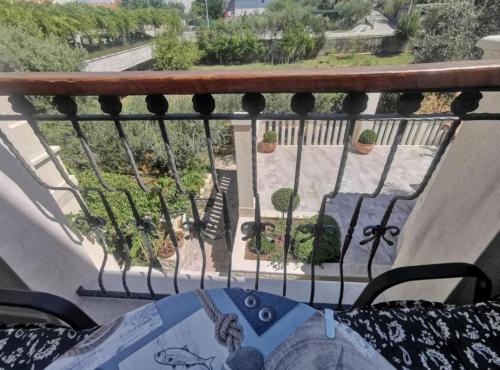 a balcony with a table and potted plants at Apartments White House in Supetar