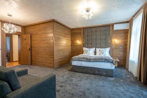 a bedroom with a large bed and a couch at V Chalet Residence in Velingrad