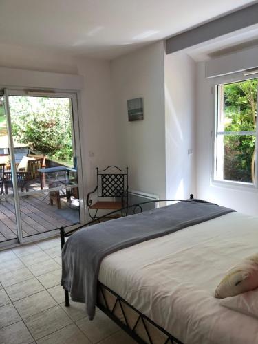 une chambre avec un grand lit et un balcon dans l'établissement Villa avec piscine pétanque ping-pong garage près golf plage, à Moliets-et-Maa