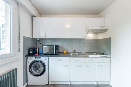 une cuisine avec un lave-linge et un micro-ondes dans l'établissement Marquer *M61* Jolie studio proche frontière, à Annemasse