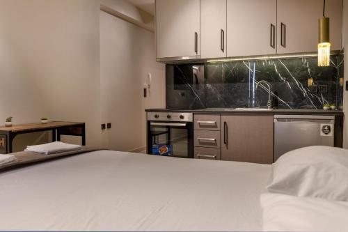 a kitchen with white cabinets and a bed in a room at Dimitra's studio in Preveza