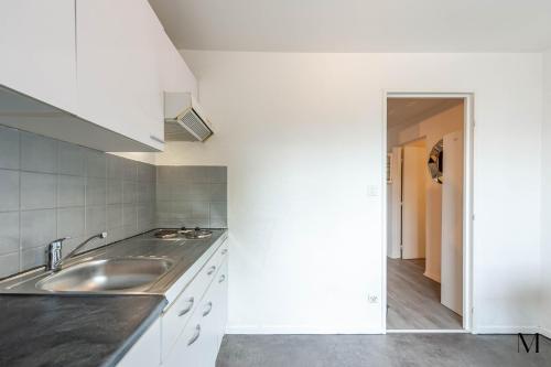 une cuisine avec des armoires blanches et un évier dans l'établissement Marquer *M61* Jolie studio proche frontière, à Annemasse
