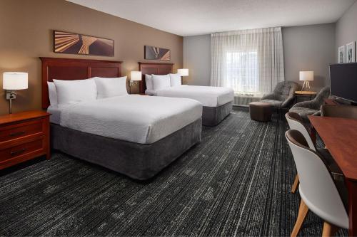 Una habitación de hotel con dos camas y un escritorio. en TownePlace Suites by Marriott Colorado Springs South, en Colorado Springs