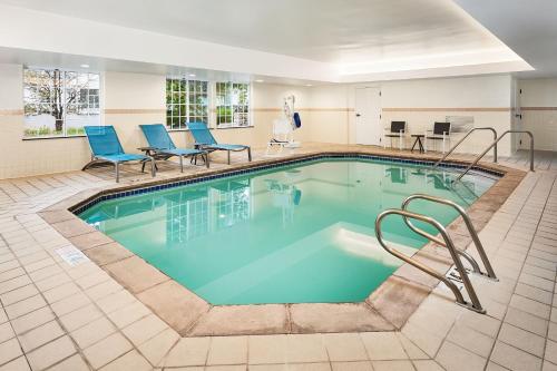 a pool in a hotel room with chairs and tables at TownePlace Suites by Marriott Colorado Springs South in Colorado Springs