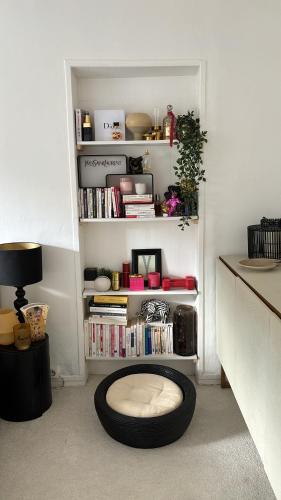 une pièce avec une étagère à livres avec un rondigunigunigunigun dans l'établissement Agréable maison de village, à Dampierre-en-Yvelines