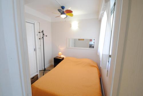 - une petite chambre avec un lit et un ventilateur de plafond dans l'établissement superbe appartement tout confort beg4012, à Cannes