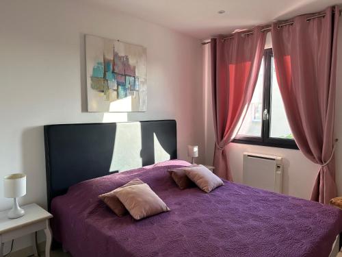 - une chambre avec un lit violet et 2 oreillers dans l'établissement Villa saona plage, à Sète