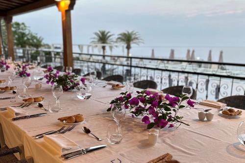 a table with purple flowers on top of a balcony at Delta Hotels by Marriott Giardini Naxos in Giardini Naxos