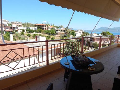 a balcony with a table and a view of the ocean at Angela's Apartment with beautiful balcony view in Agios Konstantinos Fthiotida
