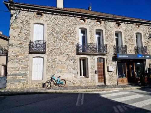 a bike parked in front of a stone building at Appartement Llapasset in Formiguères