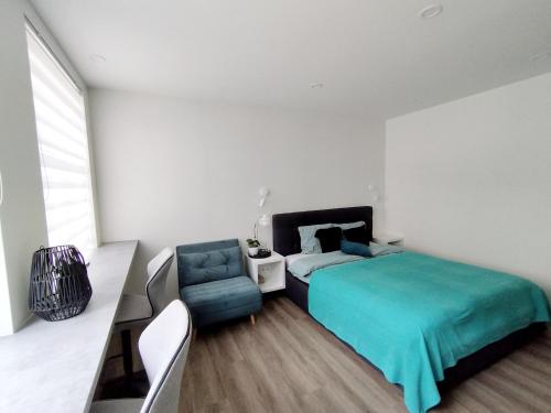 a bedroom with a bed and a couch and a chair at Modern Courtyard Condo in Liepāja