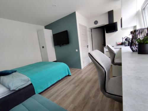 a bedroom with a bed and a table and chairs at Modern Courtyard Condo in Liepāja