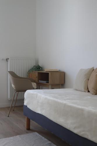 a bedroom with a bed and a desk and a chair at Oh Activ Cergy in Cergy
