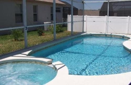 a large swimming pool with blue water in a yard at Minnie Heaven in Kissimmee
