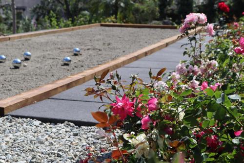 a garden with pink flowers and a wooden path at Frangimare - La Malandrina in Malfa