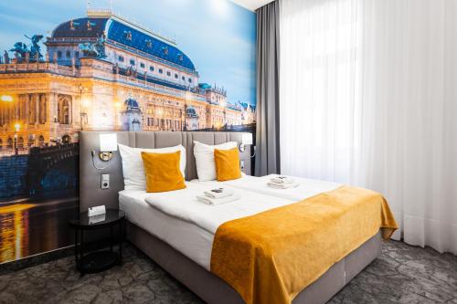 a hotel room with a large bed with a painting of a building at A1 Royal Plaza in Prague