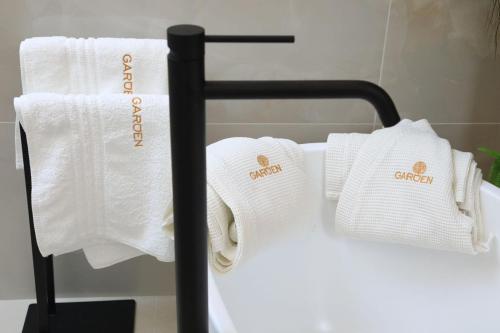 a group of towels on a towel rack in a bathroom at Garden Luxury Rooms in Split