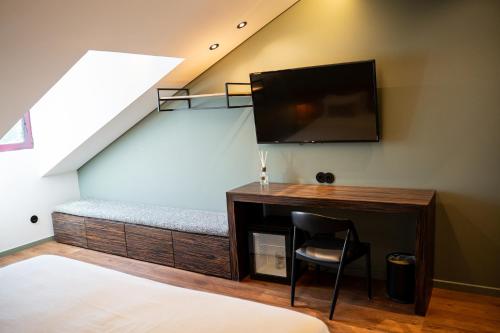 a room with a bed and a flat screen tv at Santo Thyrso Hotel in Santo Tirso