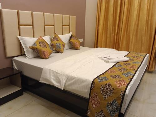 a bedroom with a large bed with pillows at Temple Tree Room in Chennai