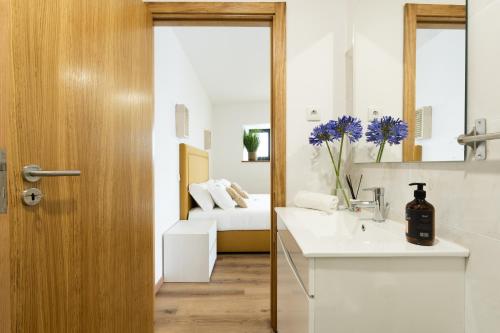 a bathroom with a sink and a room with a couch at Vale da Fonte - Charming Houses in Ponte da Barca