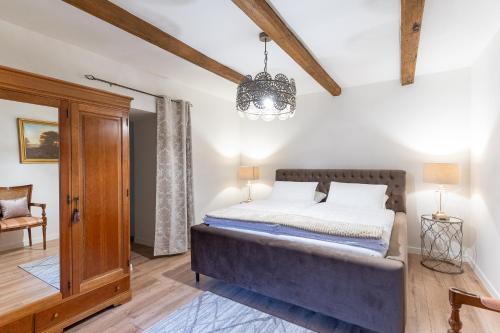a bedroom with a bed and a chandelier at Natura vendégház in Abaújvár